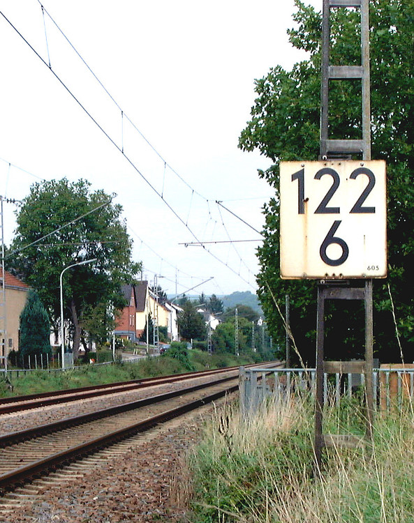 Hektometerzeichen an einem Oberleitungsmast bei Strecken­kilometer 122,6 mit Korrektur­angabe „605“ (m) (kleine Zahl unten rechts).jpg